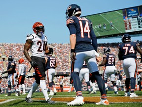 Cincinnati Bengals strong safety Vonn Bell (24) talks to Chicago Bears quarterback Andy Dalton (14) after a play and was penalized for taunting during the first quarter at Soldier Field in Chicago Sept. 19, 2021.
