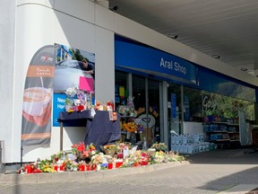 Flowers are placed in front of a gas station in Idar-Oberstein, Germany, September 21, 2021, after a 20-year-old gas station attendant who asked a customer to wear a face mask was shot dead last Saturday, September 18, 2021.