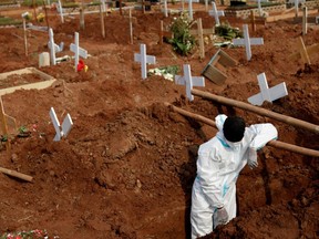 A worker wearing Personal Protective Equipment rests while preparing a grave at a burial area provided by the government for COVID-19 victims, in Bekasi, on the outskirts of Jakarta, Indonesia, July 15, 2021.