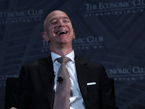 Jeff Bezos laughs as he participates in a discussion during a Milestone Celebration dinner September 13, 2018 in Washington, DC.