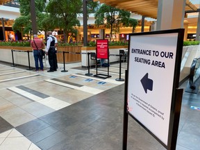 A security guard checks for proof of vaccination at the entrance to a food court during phase one of Ontario's vaccine certification program in Toronto September 22, 2021.