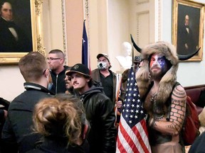 Jacob Anthony Chansley, also known as Jake Angeli, of Arizona, stands with other supporters of U.S. President Donald Trump as they demonstrate on the second floor of the U.S. Capitol near the entrance to the Senate after breaching security defences, in Washington, U.S., January 6, 2021.