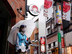 Woman who does street surveys wears a mask and a face shield, during a state of emergency amid the coronavirus disease (COVID-19) outbreak, in Tokyo, Japan August 29, 2021.