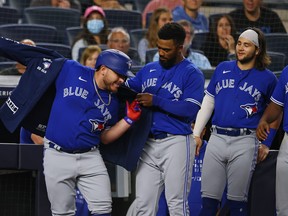 Blue Jays' Alejandro Kirk gets his home run jacket with help from Teoscar Hernandez as Bo Bichette looks on after Kirk hit a home run against the New York Yankees during the eighth inning of a game at Yankee Stadium on Wednesday, Sept. 7, 2021.