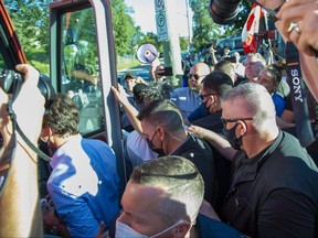 Rocks strike Prime Minister Justin Trudeau in the back as he boards his bus at the end of a campaign stop at the London Co-Operative Brewing Company in London, Ont. on September 6, 2021.