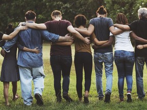 Group of friends huddle in rear view together