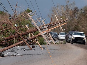 Downed utility poles cross Highway 1 in the wake of Hurricane Ida on September 1, 2021 near Larose, Louisiana.