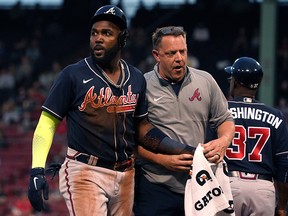 Atlanta Braves left fielder Marcell Ozuna (left) is assisted by a trainer after being injured against the Boston Red Sox at Fenway Park.