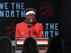 Smiling Raptors forward Pascal Siakim speaks at media day  on Monday.