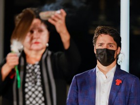 Prime Minister Justin Trudeau watches a blessing as Elder Commanda delivers a prayer including a smudging ceremony, on the eve of Canada's first National Day for Truth and Reconciliation, honouring the lost children and survivors of Indigenous residential schools, their families and communities on Parliament Hill in Ottawa, Sept. 29, 2021.