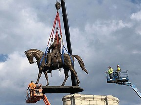 The statue of Confederate General Robert E. Lee is removed from its pedestal on Monument Avenue in Richmond, Virginia, September 8, 2021.