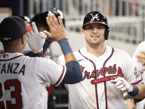 Austin Riley of the Atlanta Braves celebrates with teammates after hitting a home run during the fourth inning against the Philadelphia Phillies at Truist Park on Sept. 30, 2021 in Atlanta.