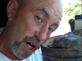 A man, identified by police as Floyd Ray Roseberry, who claims to be sitting in his truck with explosives, speaks during a Facebook livestream in a still image from video taken in Washington, August 19, 2021.