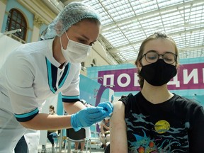 A woman receives a dose of Sputnik V (Gam-COVID-Vac) vaccine against COVID-19 at a vaccination centre in Gostiny Dvor in Moscow, July 6, 2021.