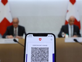 A COVID certificate is pictured on a mobile device during the news conference of Swiss Interior Minister Alain Berset and Guy Parmelin President of the Swiss Confederation on the outbreak of the coronavirus disease (COVID-19) in Bern, Switzerland, September 8, 2021.
