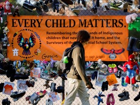 A student walks past a display at Hillcrest High School on Canada's first National Day for Truth and Reconciliation, honouring the lost children and survivors of Indigenous residential schools, their families and communities, in Ottawa, Thursday, Sept. 30, 2021.