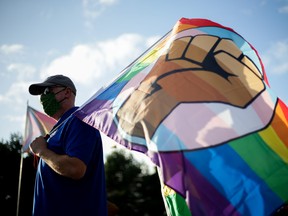 Matt Ogle of the Oregon Education Association holds a pride flag with a Black Lives Matter fist symbol as educators and supporters hold a rally to push back against the Newberg School Board's ban on educators displaying images or symbols that may be considered political or controversial September 28, 2021.