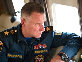 Russia's Emergencies Minister Yevgeny Zinichev sits in a helicopter as he accompanies President Vladimir Putin in a flight over wildfires sites in Chelyabinsk region, Russia August 6, 2021.