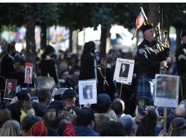 The photos of 9/11 victims are carried by family and friends as they attend a ceremony at the National 9/11 Memorial & Museum commemorating  the 20th anniversary of the 9/11 attacks on the World Trade Center, in New York, on Sept. 11, 2021.