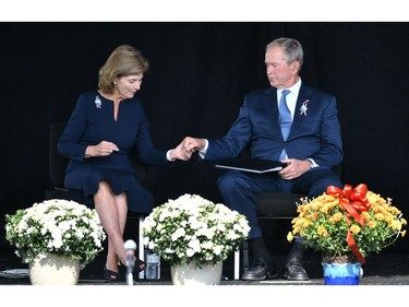 Former U.S. president George W. Bush and former first lady Laura Bush hold hands as they attend a 9/11 commemoration at the Flight 93 National Memorial in Shanksville, Pa. on Sept. 11, 2021.