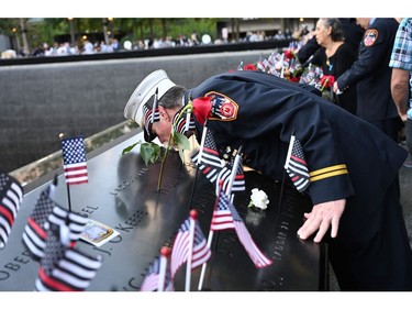 Retired Paramedic Chief Charlie Wells kisses the name of a relative killed in the attack on the World Trade Center at the National 9/11 Memorial and Museum during the ceremony commemorating the 20th anniversary of the 9/11 attacks in New York, on Sept. 11, 2021.