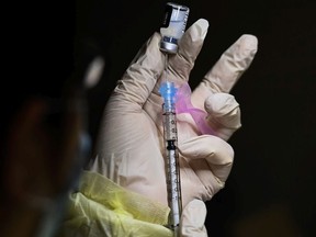 A pharmacist technician fills the Pfizer-BioNTech COVID-19 mRNA vaccine at a vaccine clinic during the COVID-19 pandemic in Toronto on Tuesday, December 15, 2020.