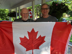 Don Cherry with Peel Regional Police Det. Robert Hackenbrook hold a Canadian flag.