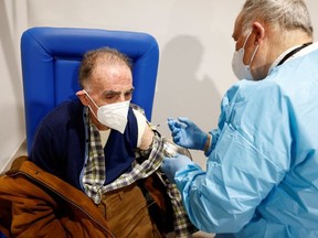 An elderly man receives a dose of the Moderna vaccine against the coronavirus disease (COVID-19) at the Music Auditorium in Rome, Italy, February 15, 2021.