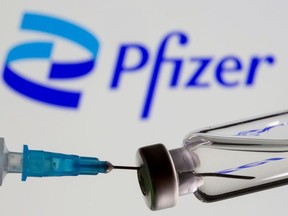 Syringe and vial are seen in front of displayed new Pfizer logo in this illustration taken, June 24, 2021.