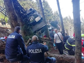 Police and rescue service members are seen near the crashed cable car after it collapsed in Stresa, near Lake Maggiore, Italy May 23, 2021.