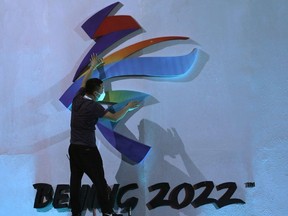 A man adjusts an emblem of the Beijing 2022 Winter Olympic Games before a ceremony unveiling the slogan, in Beijing, China September 17, 2021.