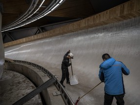 Workers prepare the ice at the National Sliding Center, that was built for the bobsled and luge events to be held at the Beijing 2022 Winter Olympics in Beijing.