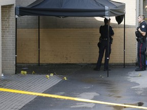 Toronto Police officers and evidence markers on Driftwood Ave. on Sept. 8, 2021, the day after a fatal shooting.