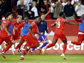 Tajon Buchanan #11 and Jonathan David #20 of Canada celebrate with Alphonso Davies #19 after Davies scores a goal in the second half during a 2022 World Cup Qualifying match against Panama at BMO Field on October 13, 2021 in Toronto.