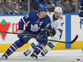 Nick Bonino of the San Jose Sharks skates against John Tavares of the Toronto Maple Leafs during an NHL game at Scotiabank Arena on October 22, 2021 in Toronto, Ontario, Canada.