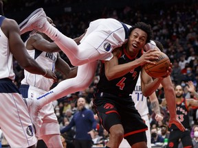 Dwight Powell #7 of the Dallas Mavericks falls over Scottie Barnes on Saturday night.