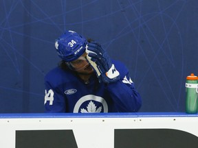 Toronto Maple Leafs' Auston Matthews sits on the bench after a hard training skate during training camp.