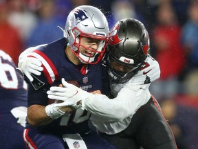 Mac Jones of the New England Patriots gets sacked by Joe Tryon-Shoyinka of the Tampa Bay Buccaneers on Sunday night. Jones was impressive in the Patriots' loss.