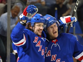 Artemi Panarin #10 of the New York Rangers (L) celebrates a second period goal by Adam Fox #23 (R) against the Dallas Stars at Madison Square Garden on October 14, 2021 in New York City.