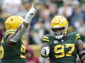 Kenny Clark #97 celebrates with teammates after recording a sack in the fourth quarter against the Washington Football Team in the game at Lambeau Field on October 24, 2021 in Green Bay, Wisconsin.