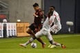 Atlanta United's Luiz Araujo is tackled by Toronto FC's Kemar Lawrence (92) and Richie Laryea (22).