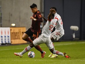 Atlanta United's Luiz Araujo is tackled by Toronto FC's Kemar Lawrence (92) and Richie Laryea (22).