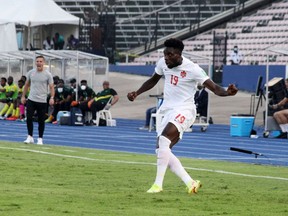 Alphonso Davies of Canada crosses a ball against Jamaica in a FIFA World Cup Qualifying game in Kingston, Jamaica on Oct. 10, 2021.