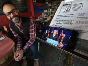Vito Marinuzzi, owner of 7 Numbers restaurant on Danforth Ave., excitedly watches the Ontario government's announcement regarding businesses returning to full capacity on Friday, Oct. 22, 2021.