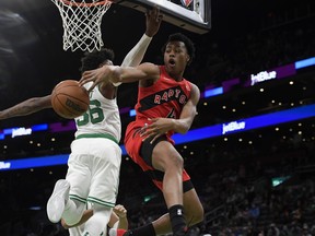 Raptors forward Scottie Barnes (right) passes the ball around Celtics guard Marcus Smart at TD Garden in Boston last night.