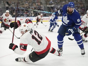 Maple Leafs defenceman Jake Muzzin (8) knocks Ottawa Senators forward Shane Pinto (12) over during the first period at Scotiabank Arena on Saturday.