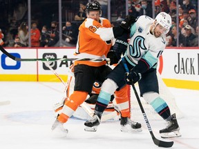 Seattle Kraken centre Riley Sheahan (15) controls the puck in front of Philadelphia Flyers defenceman Justin Braun
