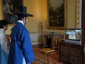 Queen Elizabeth appears on a screen via video link from Windsor Castle, where she is in residence, during a virtual audience to receive the Ambassador from the Republic of Korea, Gunn Kim, accompanied by HeeJung Lee, at Buckingham Palace on October 26, 2021.