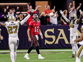 The Saints defence celebrates as Tampa Bay Buccaneers quarterback Tom Brady (12) walks back to the sideline after throwing an interception for a touchdown to cornerback P.J. Williams during the second half at Caesars Superdome.