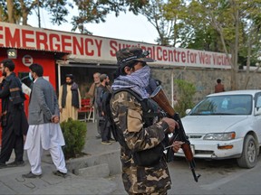 A Taliban fighter stands guard outside the entrance of a hospital where the victims of an explosion are to be brought, in Kabul on Oct. 3, 2021.